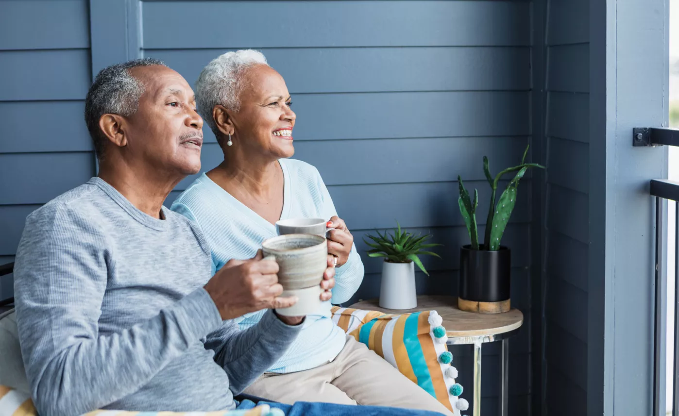  Retirement-aged man and woman drinking coffee on porch
