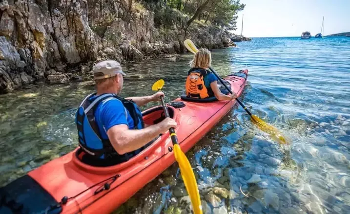  A retirement-aged couple enjoys a kayaking excursion on a sunny day.
