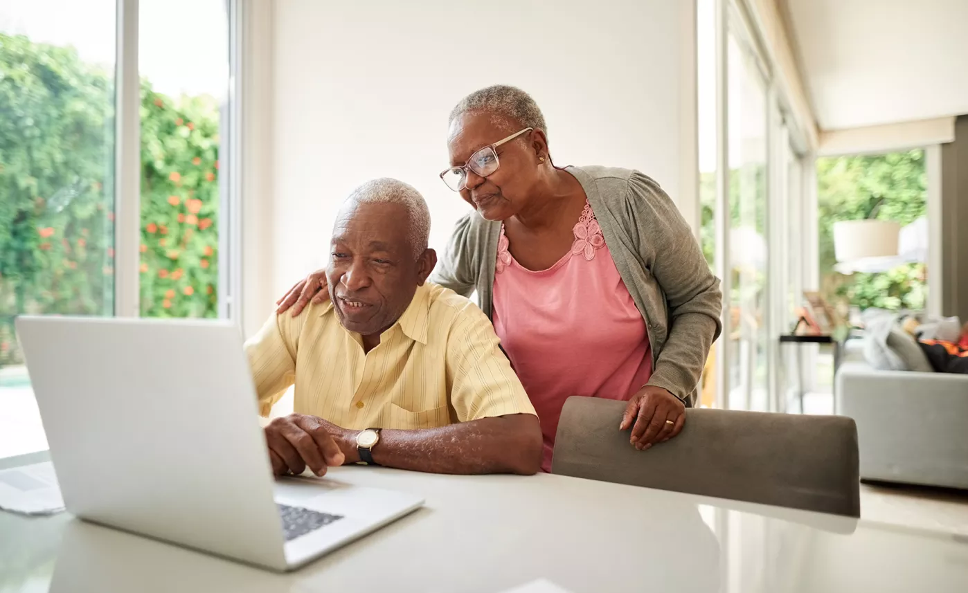  A retirement-aged couple reviews their portfolio online, considering the role that risk plays in retirement.
