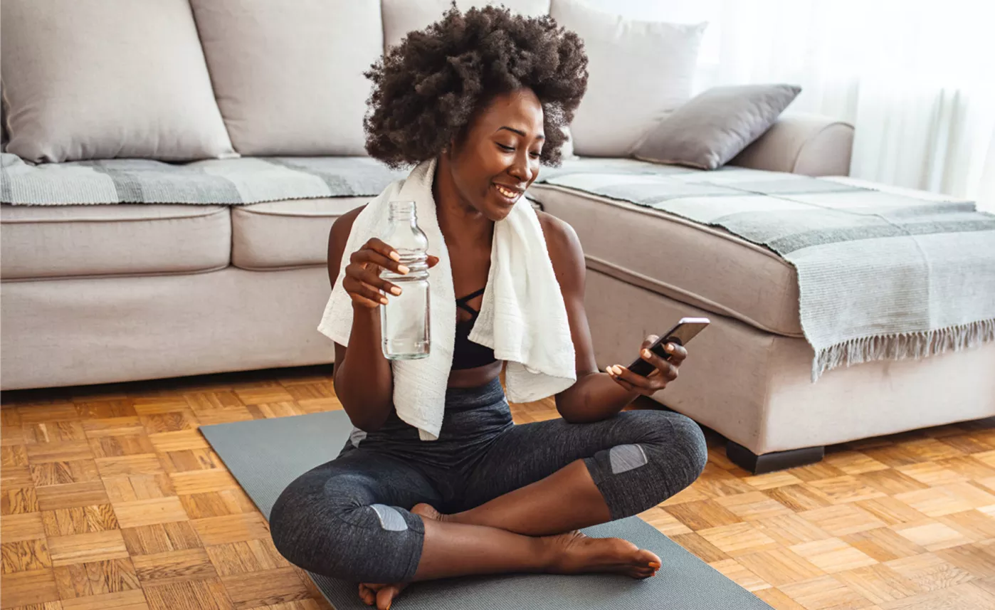  image of women doing yoga and checking on phone
