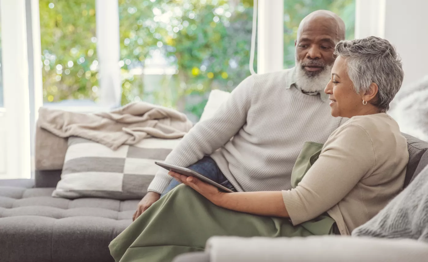  An older retired couple reviewing their finances on an ipad
