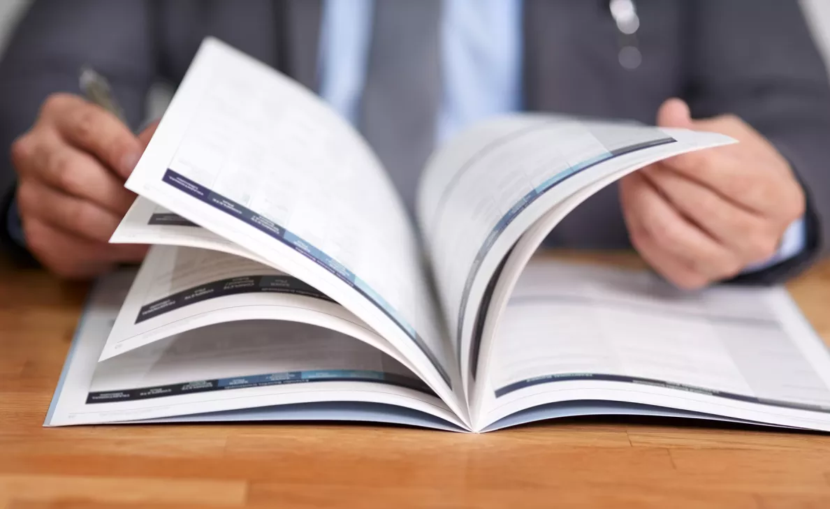 A client flips through a pamphlet containing information about Edward Jones.