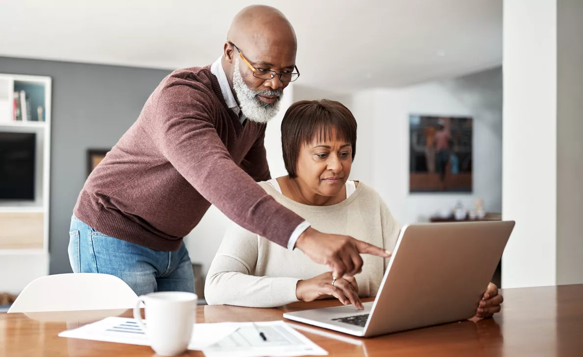 A man and woman viewing tax information on a laptop computer