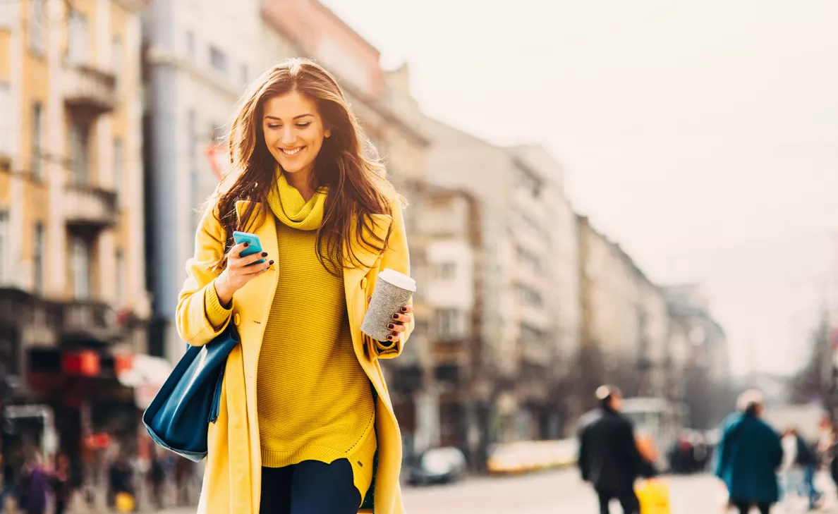 A client reviews her portfolio on her mobile phone through the Edward Jones app while on the go.