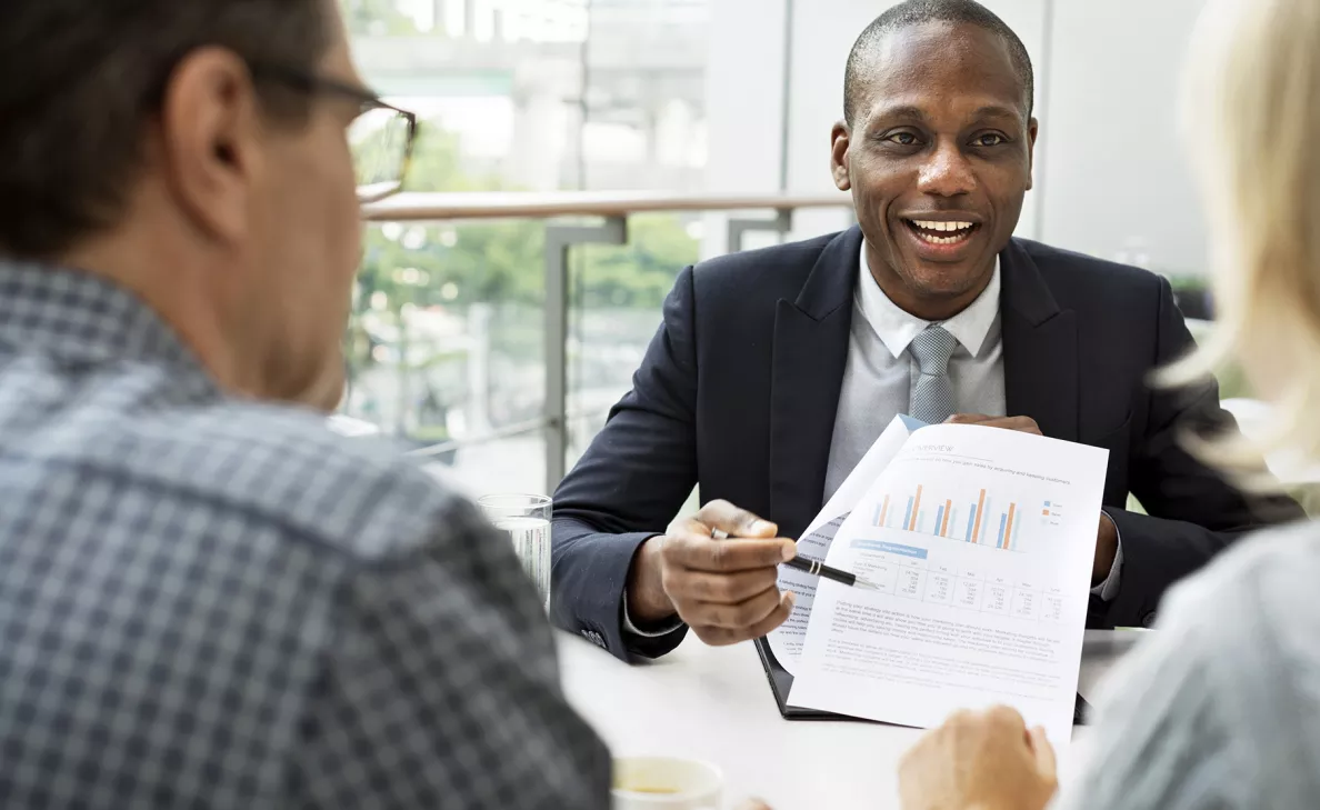 A financial advisor goes over charts and graphs with two clients.
