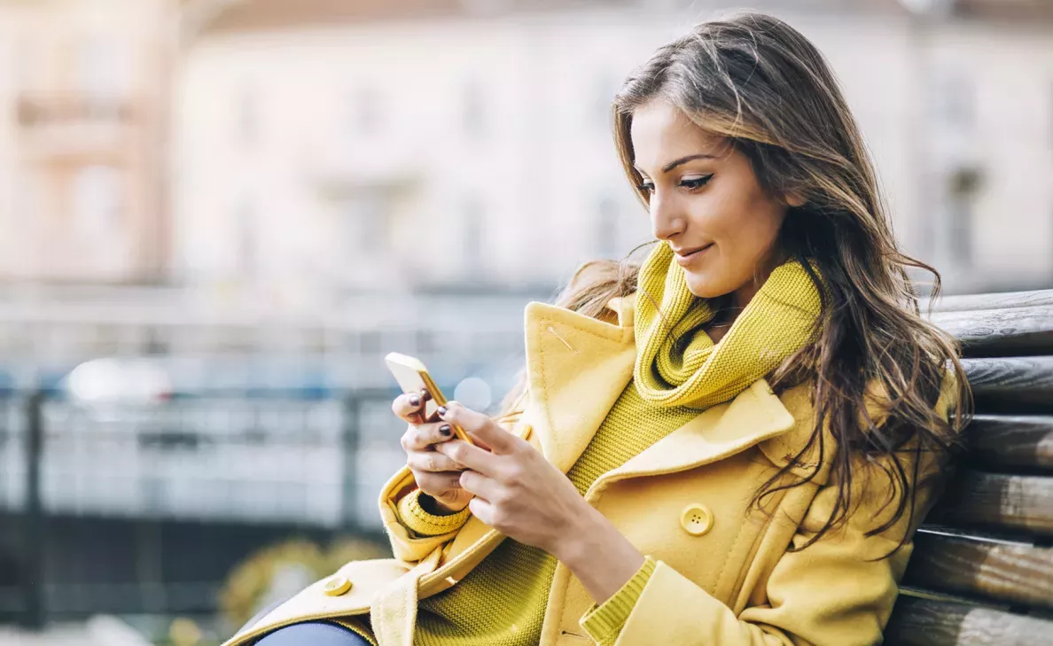 Woman siting on a bench looking at her phone