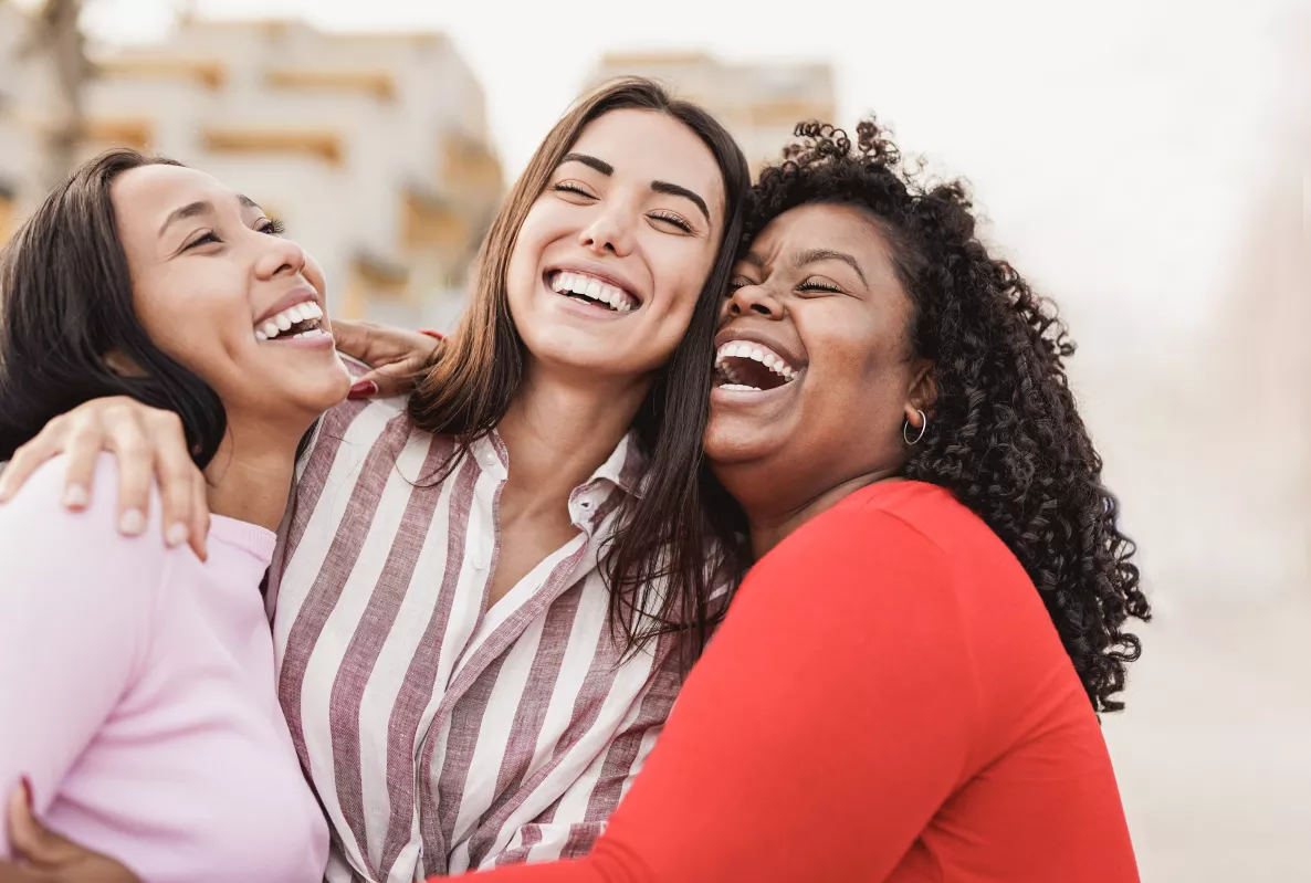  Three women hugging and smiling
