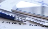 A pen and legal trust paper on top of a last will and testament.