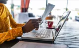 A woman reviews her tax forms at a cafe.